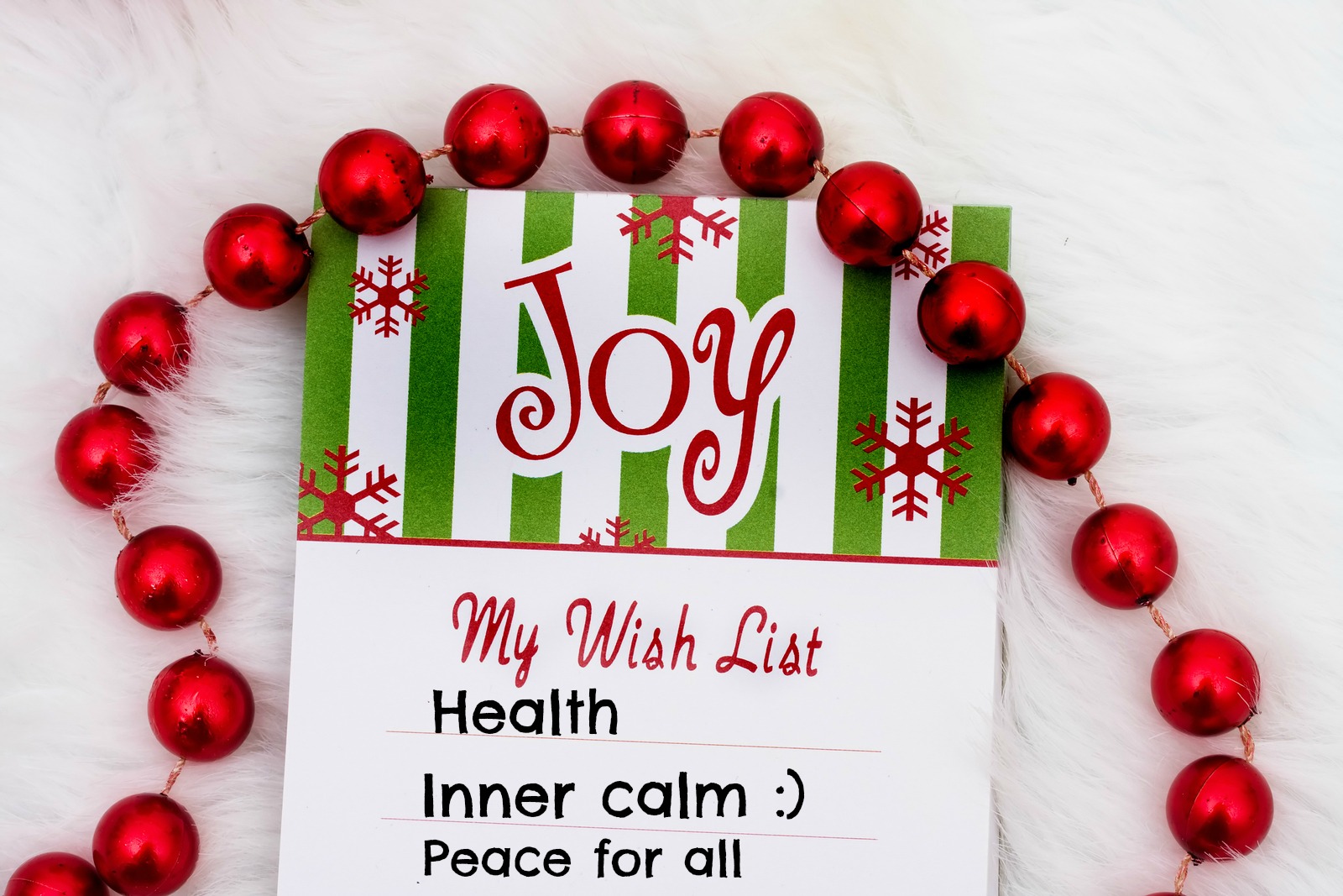 A Christmas wish list decorated with small baubles. The list has three items: health, inner calm and peace for all