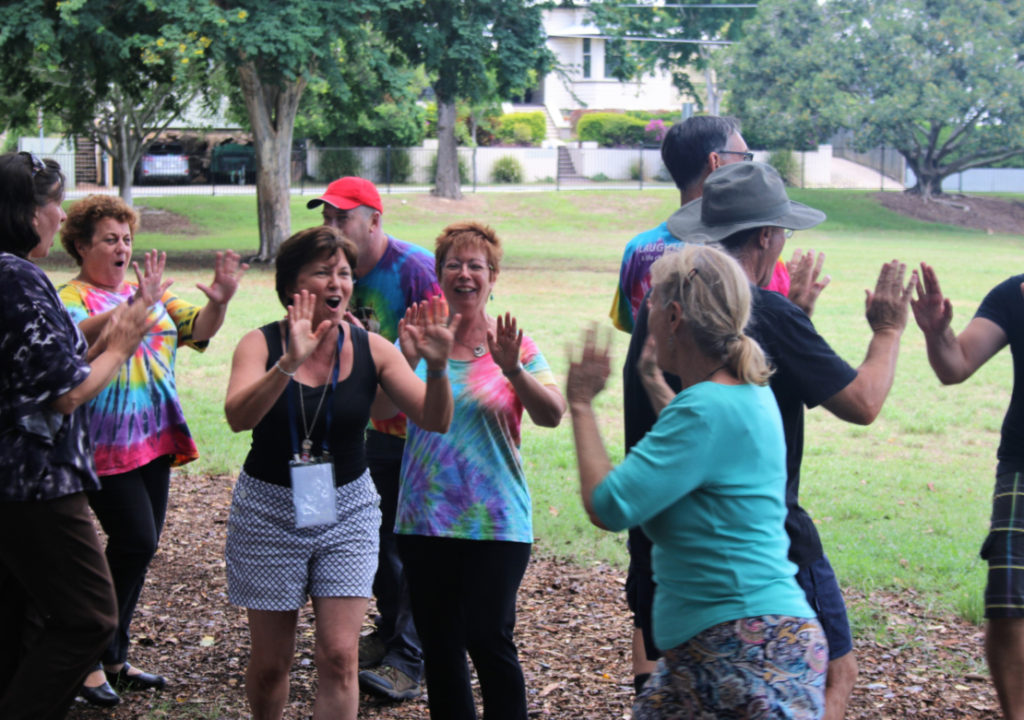 People standing outside with hands up in front of them looking at each other