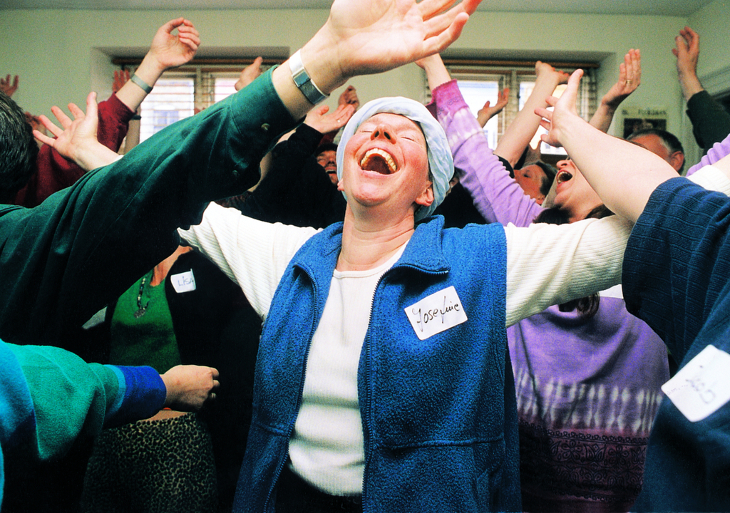 workplace wellness workshops shows group with hands outstretched eyes closed and huge smiles