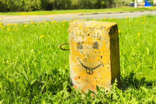 rectangular gravestone with a smiley face drawn on it