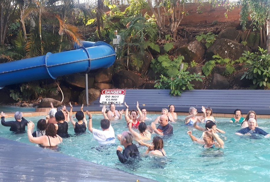People in a pool doing aqua laughter class