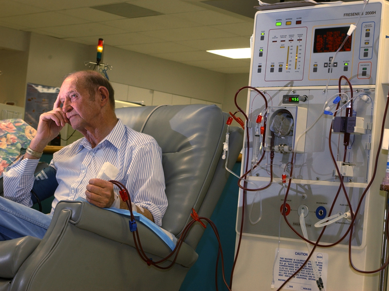 Elderly man in recliner hooked up to a dialysis machine