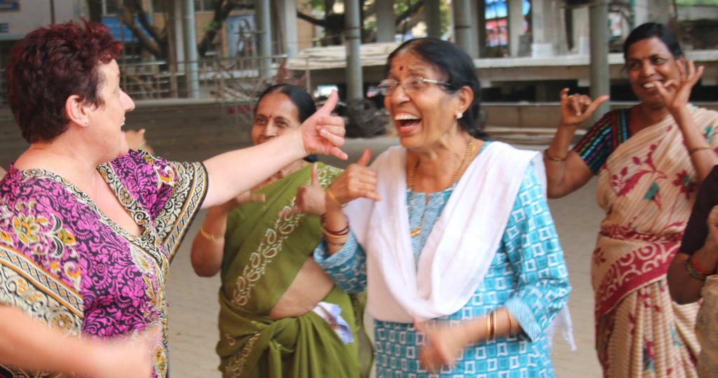 Three Indian women in traditional dress with Heather Joy all laughing