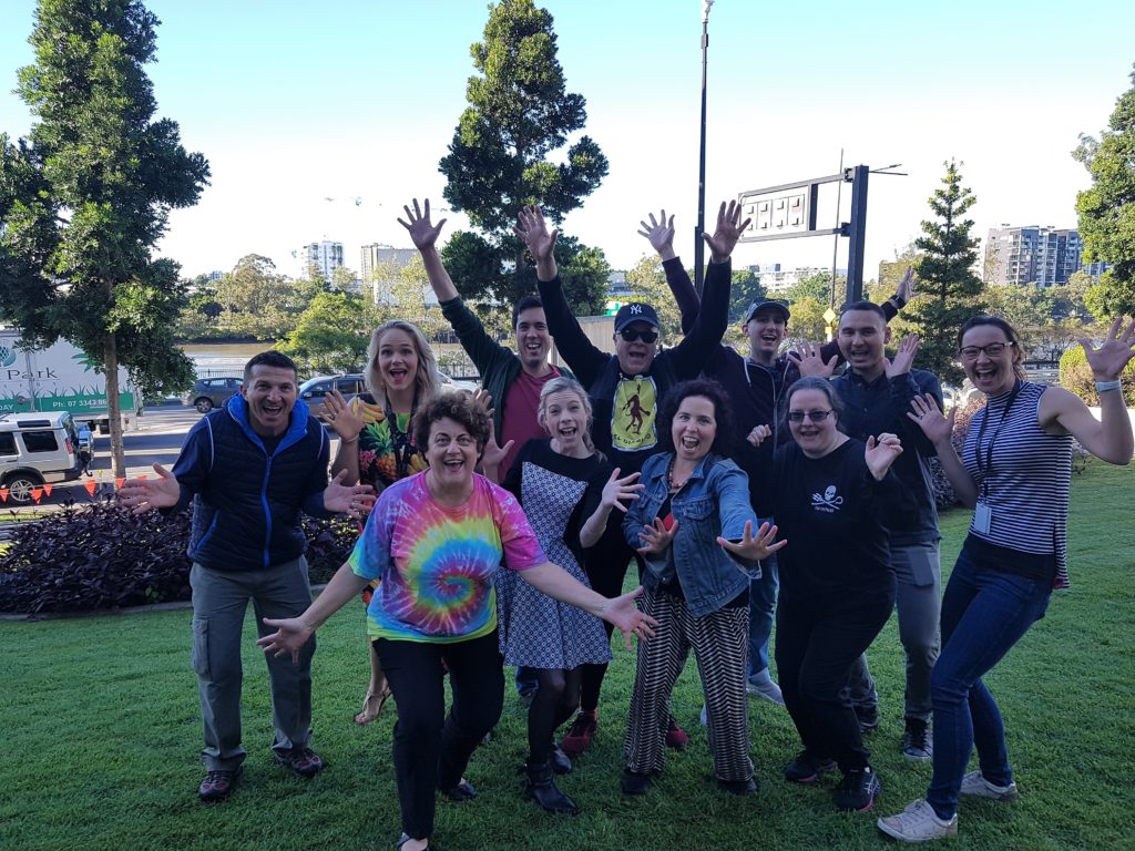 A work group laughing and looking happy  during a laughter yoga session.