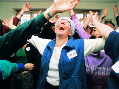 workplace wellness workshops shows group with hands outstretched eyes closed and huge smiles