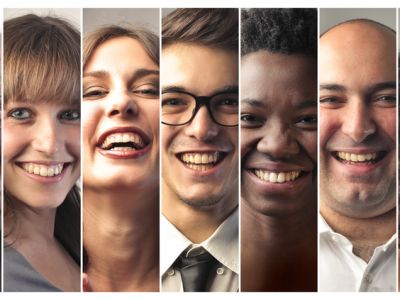 Many men and women of diverse ethnicities and ages smiling and laughing