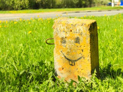 rectangular gravestone with a smiley face drawn on it